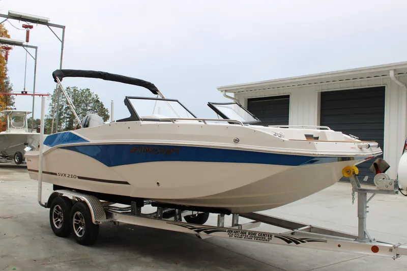 Slide: The Image of 2024 Starcraft SVX 210 OB DC boat on trailer, parked outdoors. - 4