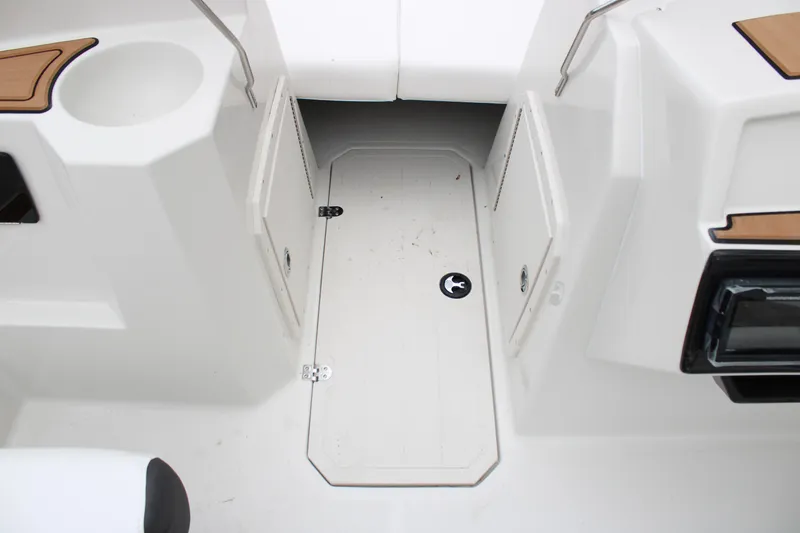 Slide: The Image of 2024 Starcraft SVX 210 OB DC boat interior with storage compartment and cup holder. - 8
