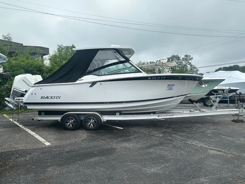 Slide: The Image of 2020 Blackfin 272 DC boat on a trailer in a parking lot. - 0