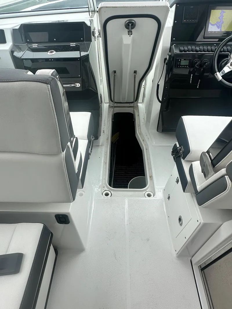 Slide: The Image of 2020 Blackfin 272 DC boat interior with open storage compartment and modern dashboard. - 27