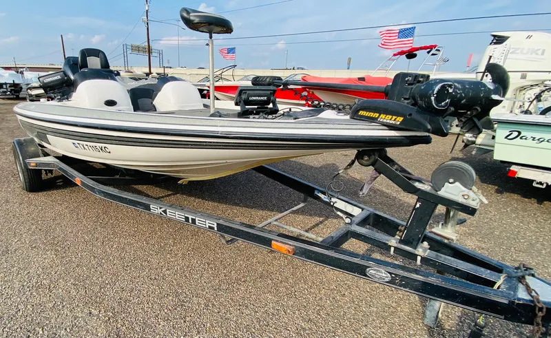 The Image of 2005 Skeeter SX190 boat on trailer, displayed outdoors with American flags in background. - 1