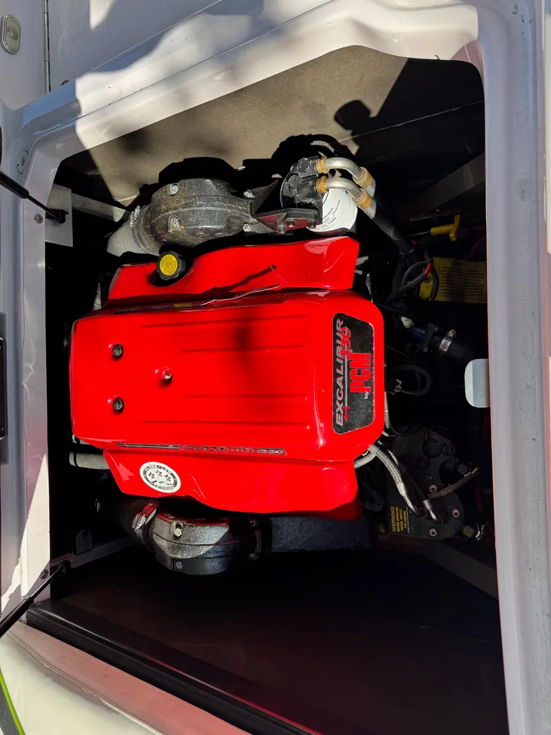Slide: The Image of 2004 Correct Craft AIR NAUTIQUE SV 211 engine with red cover, detailed view. - 11