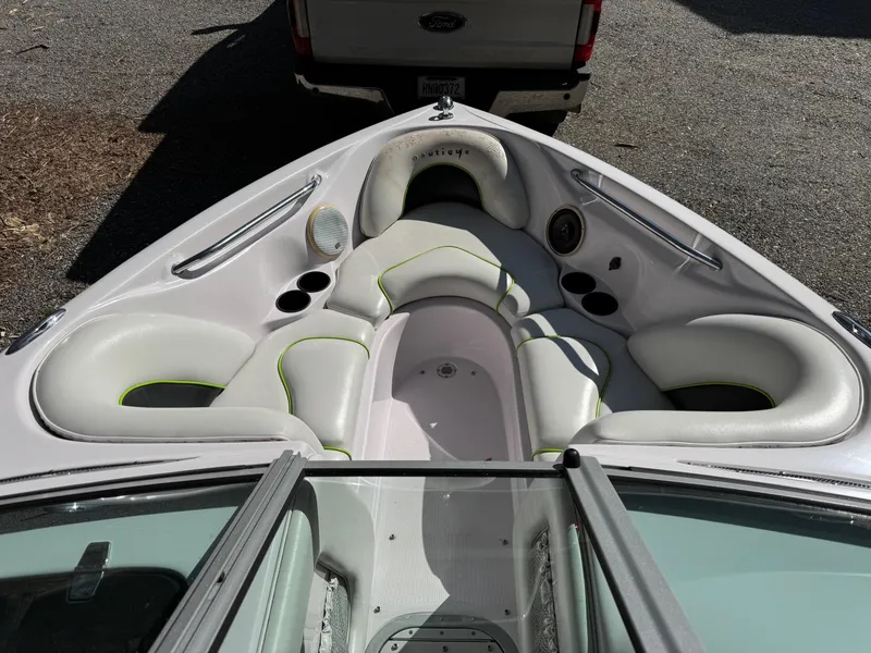 Slide: The Image of 2004 Correct Craft AIR NAUTIQUE SV 211 boat interior with white seating and cup holders. - 12