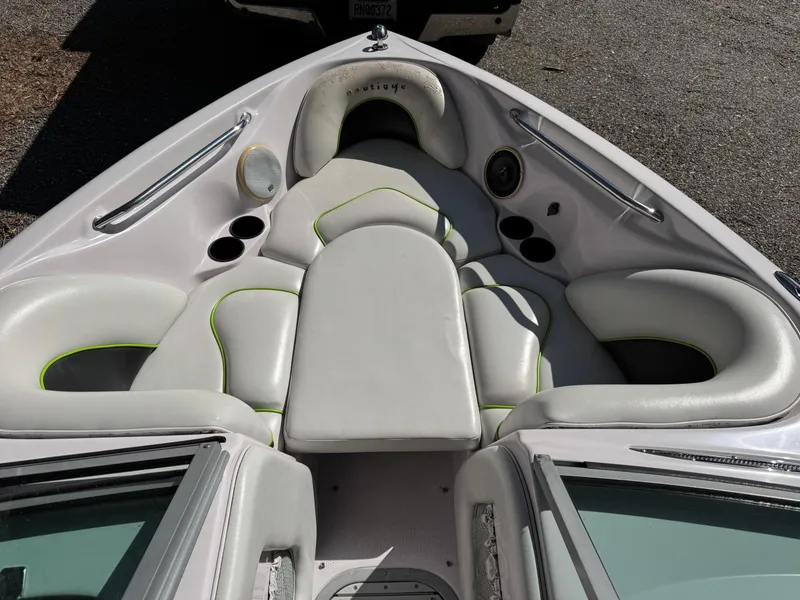 Slide: The Image of 2004 Correct Craft AIR NAUTIQUE SV 211 boat interior with white seating and cup holders. - 13