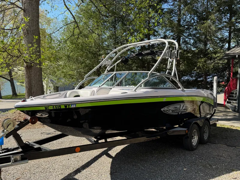 Slide: The Image of 2004 Correct Craft AIR NAUTIQUE SV 211 boat on trailer, parked outdoors. - 3