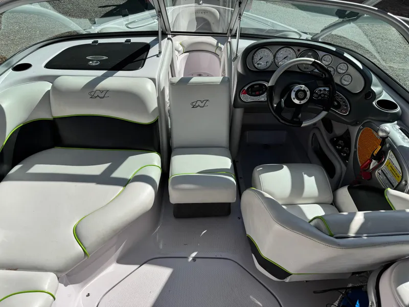 Slide: The Image of 2004 Correct Craft AIR NAUTIQUE SV 211 boat interior with modern dashboard and seating. - 5