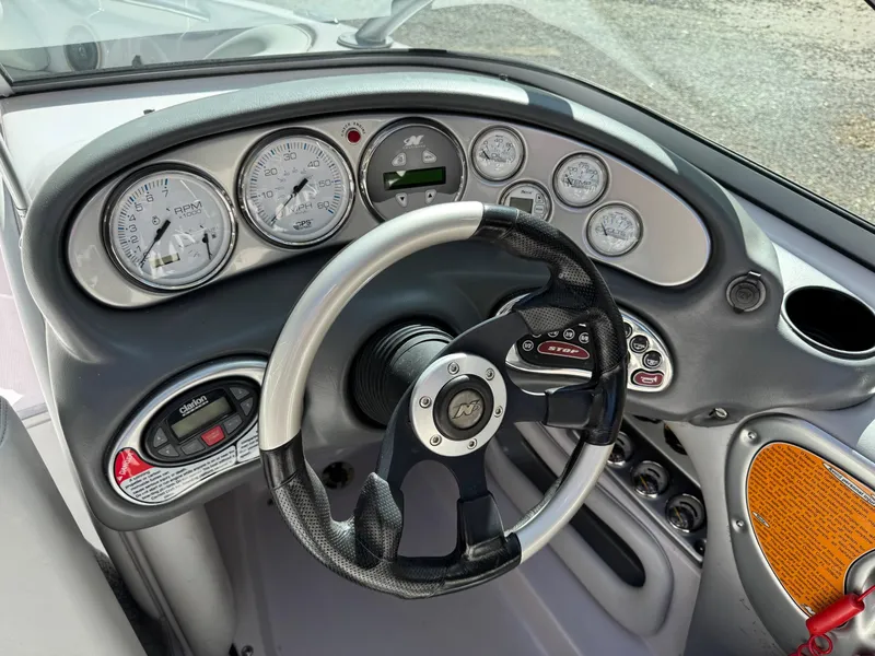 Slide: The Image of Dashboard of 2004 Correct Craft AIR NAUTIQUE SV 211 boat with steering wheel and gauges. - 7