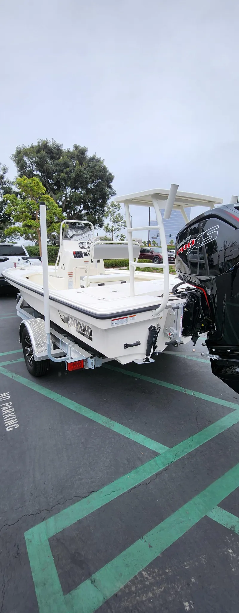 Slide: The Image of 2025 Mako 18 LTS boat on trailer in parking lot. - 2