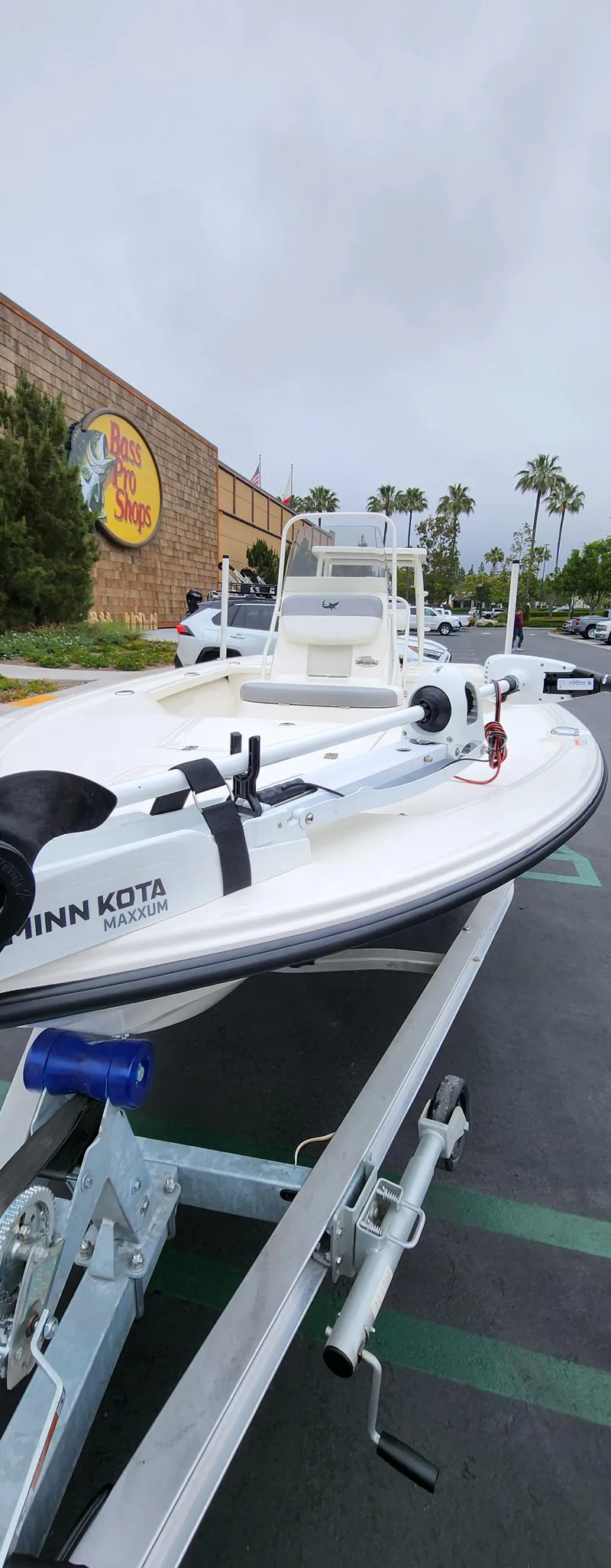Slide: The Image of 2025 Mako 18 LTS boat on trailer outside a store, overcast sky. - 5