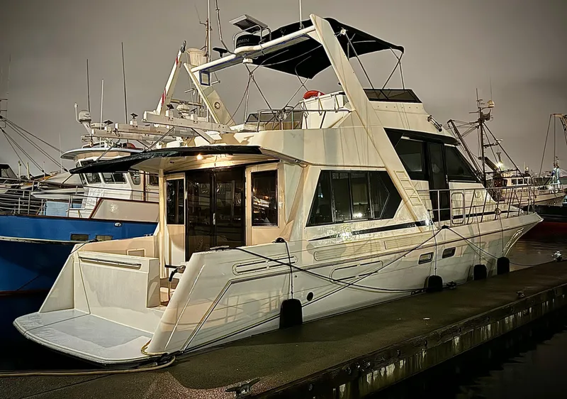 Slide: The Image of 1993 Navigator 5000 Classic yacht docked at marina, illuminated at night. - 1