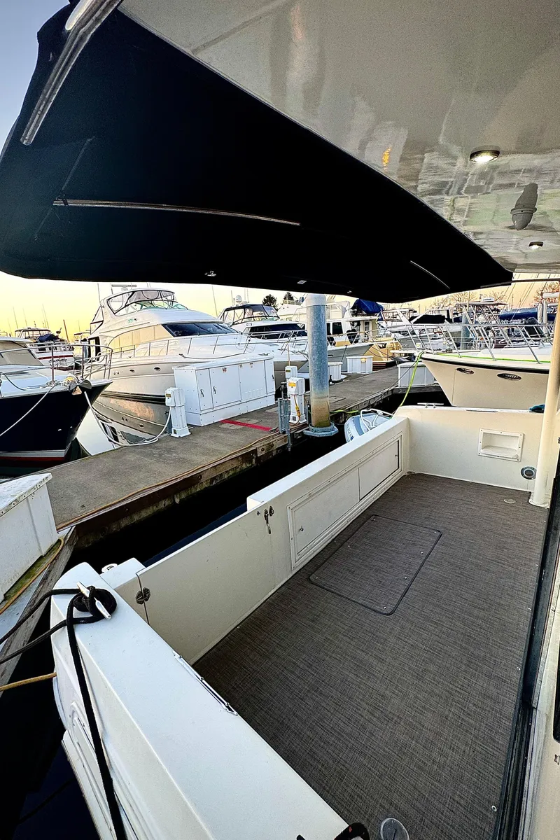 Slide: The Image of 1993 Navigator 5000 Classic yacht docked at marina, featuring spacious deck and modern canopy. - 49