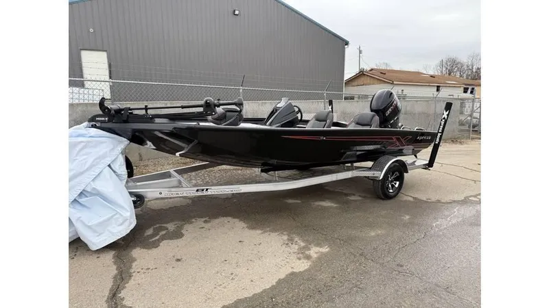 Slide: The Image of 2025 Xpress H18 boat on trailer, parked outdoors near industrial building. - 5