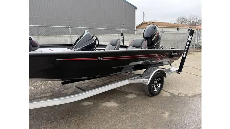 Slide: The Image of 2025 Xpress H18 boat on trailer, black with red accents, parked outdoors. - 6