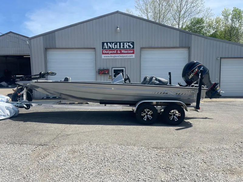 Slide: The Image of 2025 Xpress H20 boat on trailer outside Anglers Outpost & Marine building. - 1