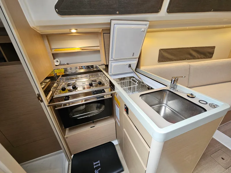 Slide: The Image of Compact kitchen in 2022 Beneteau Oceanis 30.1 yacht with stove, sink, and storage. - 12