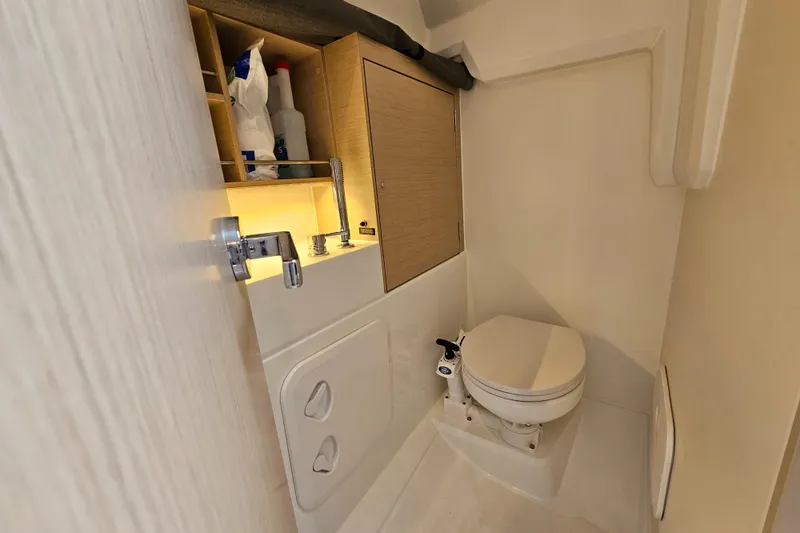Slide: The Image of Beneteau Oceanis 30.1 2022 yacht bathroom with toilet and storage shelves. - 16