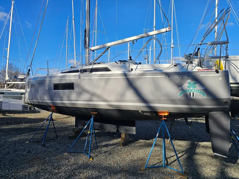 Slide: The Image of 2022 Beneteau Oceanis 30.1 sailboat on stands, displayed outdoors under clear blue sky. - 4