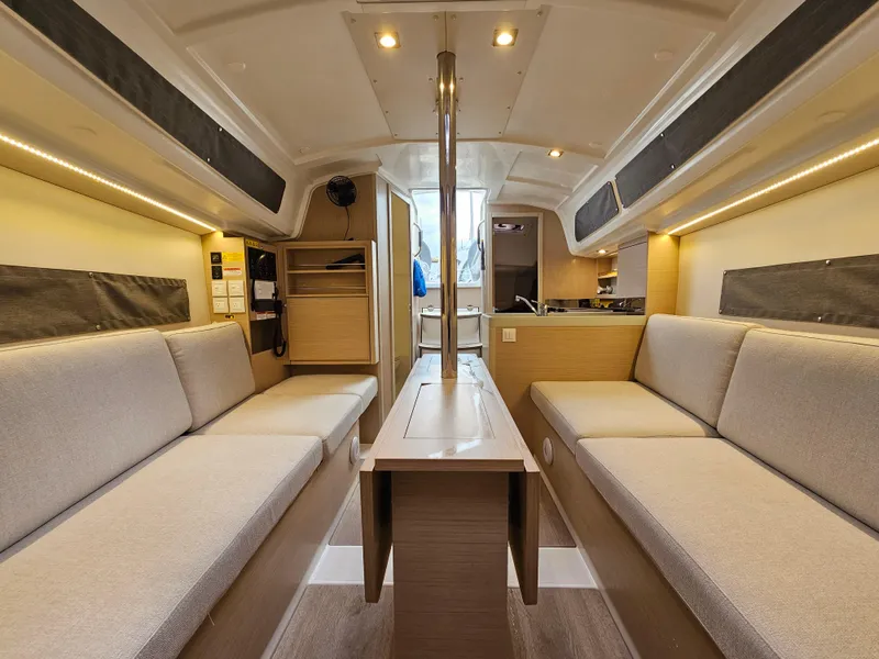 Slide: The Image of Interior of 2022 Beneteau Oceanis 30.1 sailboat, featuring modern seating and wooden finishes. - 9