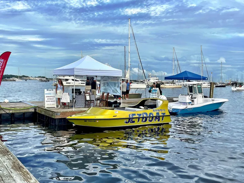 Slide: The Image of Docked Smoky Mountain SMJB 21 jet boat at marina with tents and people, 2014 model. - 3