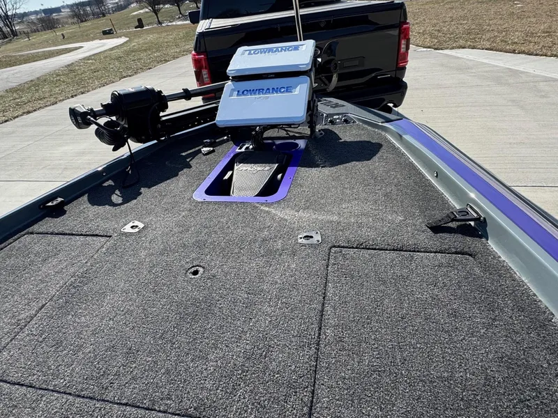 Slide: The Image of 2025 Bullet 21XST boat with Lowrance electronics, parked on a concrete surface. - 12