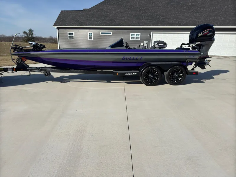 Slide: The Image of 2025 Bullet 21XST boat on trailer, parked in driveway, with modern design and sleek appearance. - 14