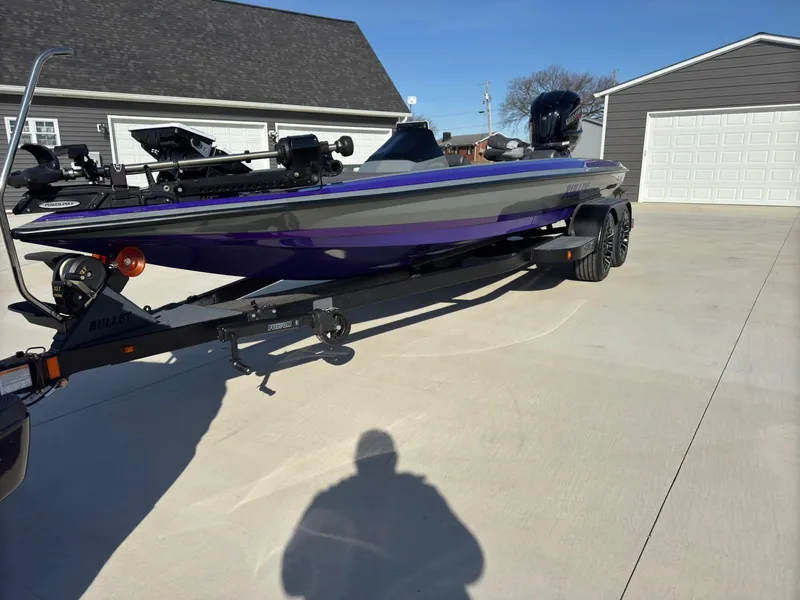 Slide: The Image of 2025 Bullet 21XST boat on trailer, parked in driveway, with purple and gray design. - 15