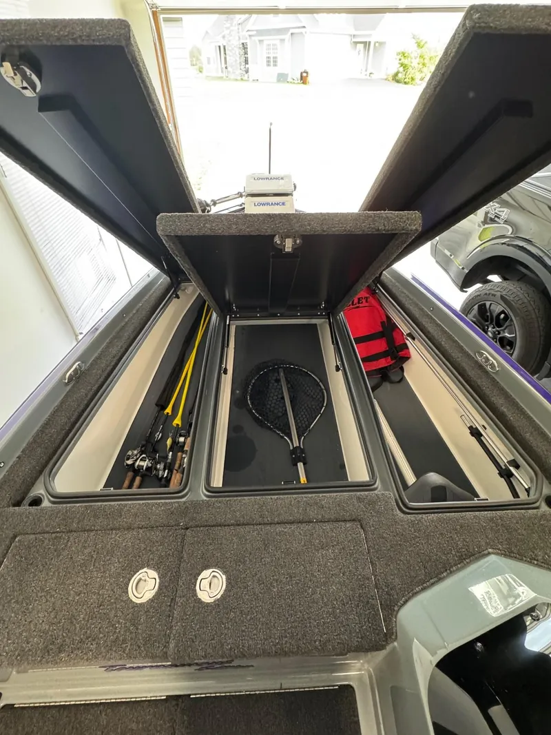 Slide: The Image of Open storage compartments in a 2025 Bullet 21XST boat, featuring fishing gear and equipment. - 9