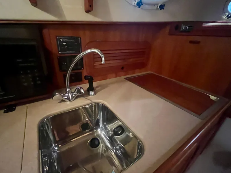 Slide: The Image of 2005 Hinckley Picnic Boat EP interior with sink and wooden cabinetry. - 10