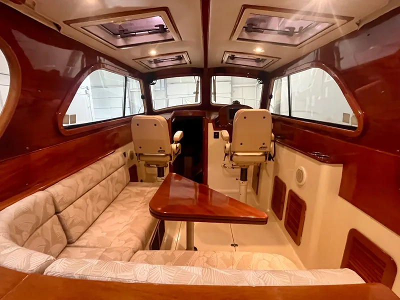 Slide: The Image of 2005 Hinckley Picnic Boat EP interior with wood accents and cushioned seating. - 2