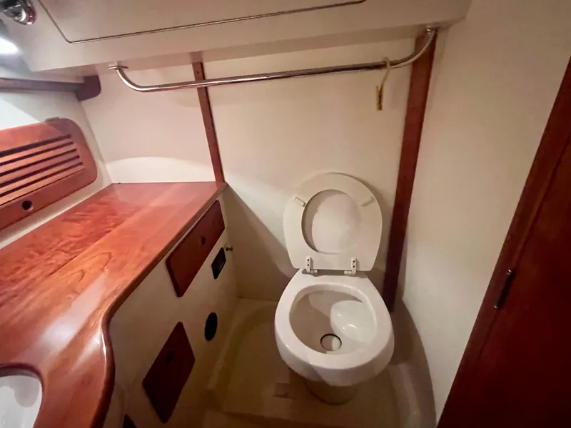 Slide: The Image of 2005 Hinckley Picnic Boat EP interior bathroom with wooden accents and toilet. - 20