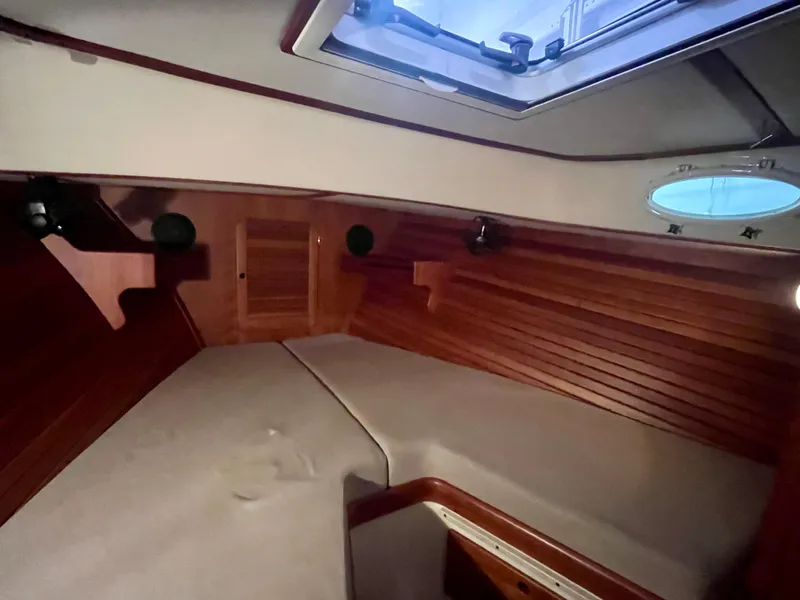 Slide: The Image of 2005 Hinckley Picnic Boat EP cabin interior with wood paneling and skylight. - 28