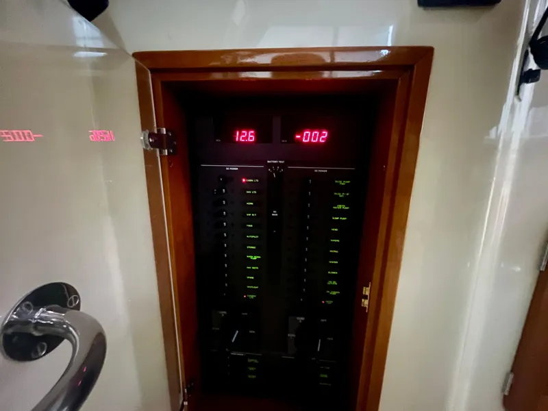 Slide: The Image of Electrical panel inside a 2005 Hinckley Picnic Boat EP, displaying voltage and current readings. - 36