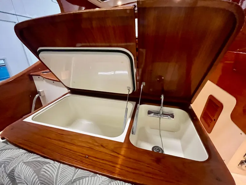 Slide: The Image of 2005 Hinckley Picnic Boat EP interior with open wooden storage and sink. - 39