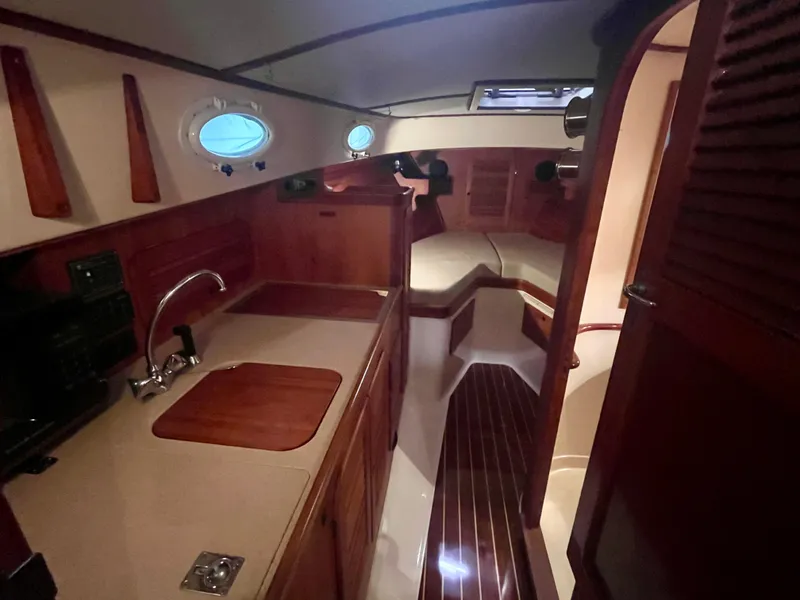 Slide: The Image of 2005 Hinckley Picnic Boat EP interior with wood finish, kitchenette, and seating area. - 7