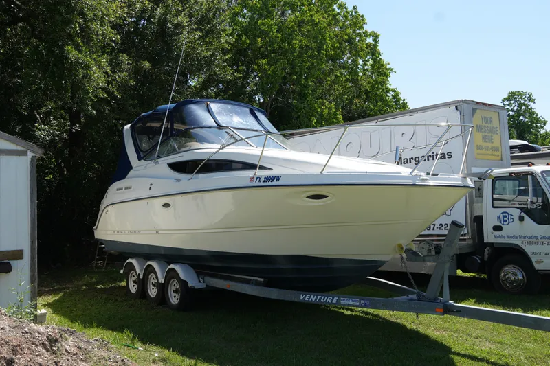 The Image of 2003 Bayliner Ciera 2855 boat on trailer, parked outdoors near trees. - 0