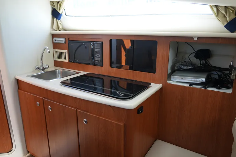 Slide: The Image of 2003 Bayliner Ciera 2855 interior kitchen with sink, stove, and microwave. - 17