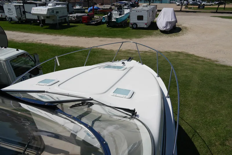 Slide: The Image of 2003 Bayliner Ciera 2855 boat parked on grass near RVs and trailers. - 6