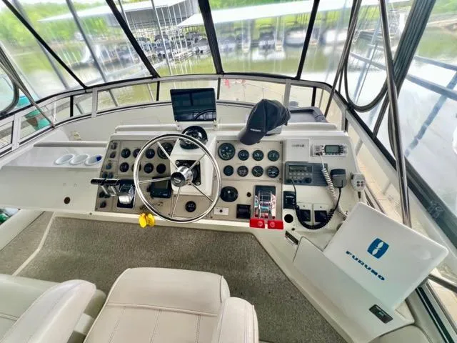 Slide: The Image of 1998 Carver 405 Motor Yacht helm with steering wheel, gauges, and navigation equipment. - 13