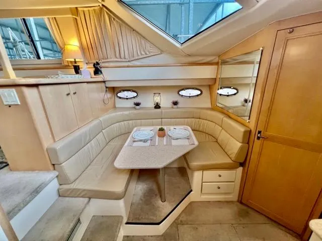 Slide: The Image of 1998 Carver 405 Motor Yacht interior with cozy dining area and elegant wood finishes. - 19