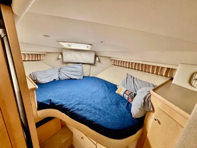 Slide: The Image of 1998 Carver 405 Motor Yacht bedroom with blue bedding and cozy interior design. - 20