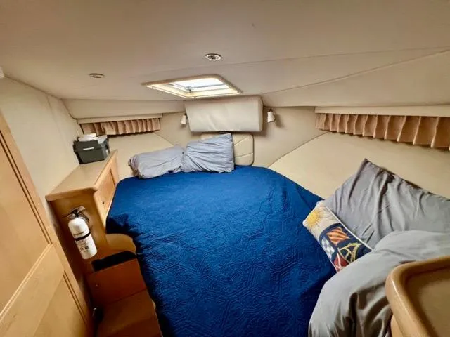 Slide: The Image of 1998 Carver 405 Motor Yacht cabin with blue bedding and skylight. - 21