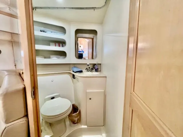 Slide: The Image of 1998 Carver 405 Motor Yacht bathroom with toilet, shelves, and mirror. - 22