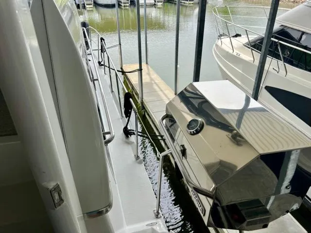 Slide: The Image of 1998 Carver 405 Motor Yacht docked, featuring a sleek deck and stainless steel grill. - 35