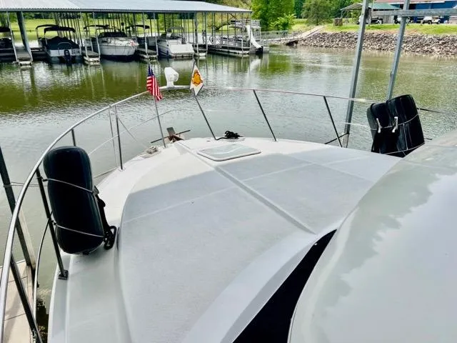 Slide: The Image of 1998 Carver 405 Motor Yacht docked at marina with scenic water view. - 36