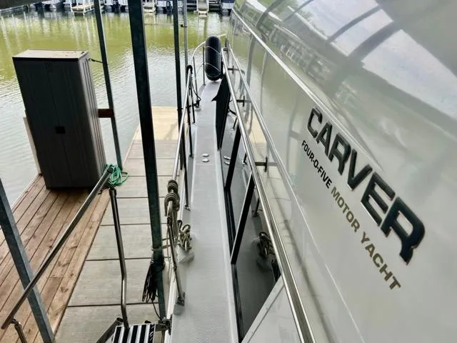 Slide: The Image of 1998 Carver 405 Motor Yacht docked, showcasing sleek design and branding. - 41
