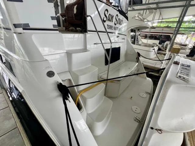 Slide: The Image of 1998 Carver 405 Motor Yacht docked, featuring rear steps and mooring lines. - 8