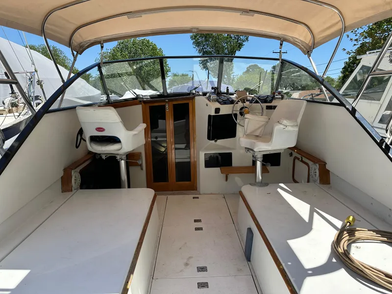 Slide: The Image of 1988 Black Watch 30 EXPRESS boat interior with helm seats and canopy. - 8