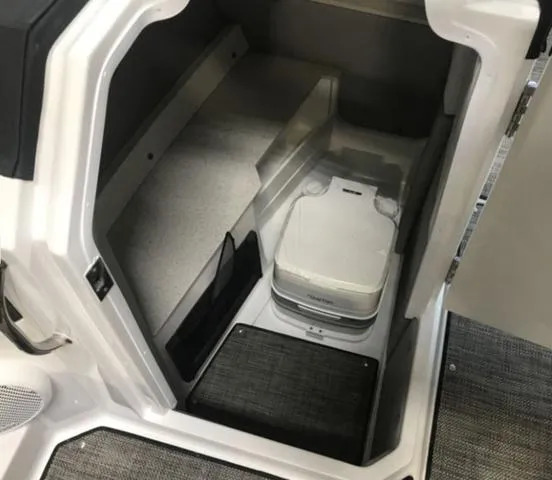Slide: The Image of 2024 Cobalt R6 Surf boat interior storage compartment with portable toilet. - 11