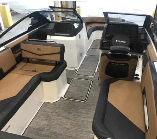 Slide: The Image of 2024 Cobalt R6 Surf boat interior with tan and black seating, modern dashboard, and spacious layout. - 3