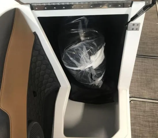 Slide: The Image of Storage compartment in a 2024 Cobalt R6 Surf boat, featuring a wrapped item inside. - 5